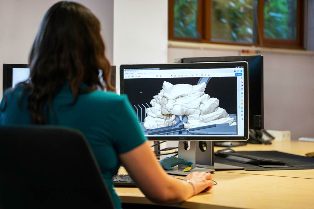 A designer working on a 3D model in CAD software
