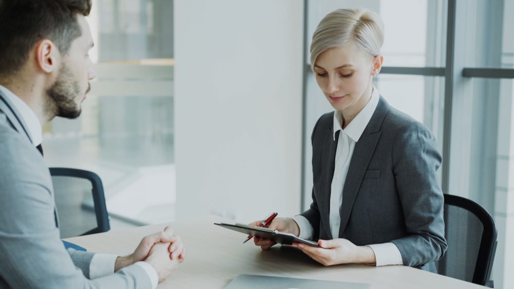 Two professionals working through a decision in a modern office