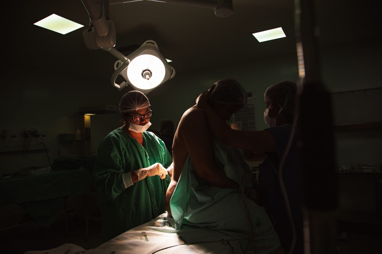 Surgeons and nurses preparing for an operation under bright surgical lights