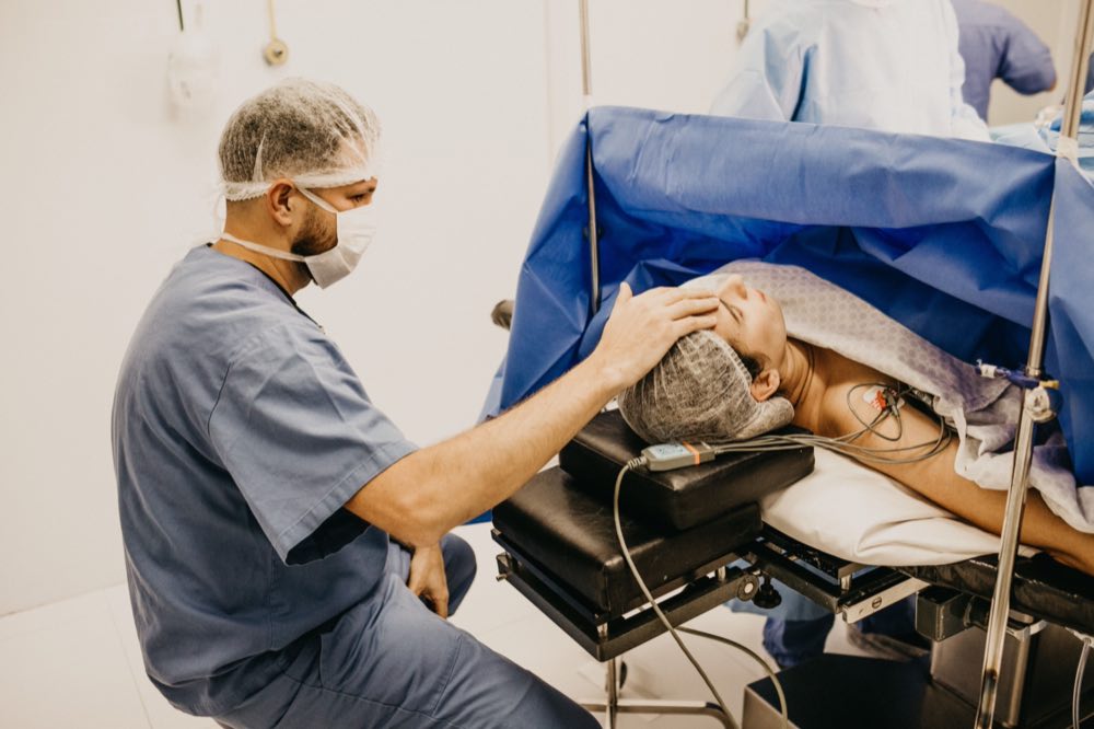 Surgeon offering comfort to a patient about to undergo surgery in a hospital operating room