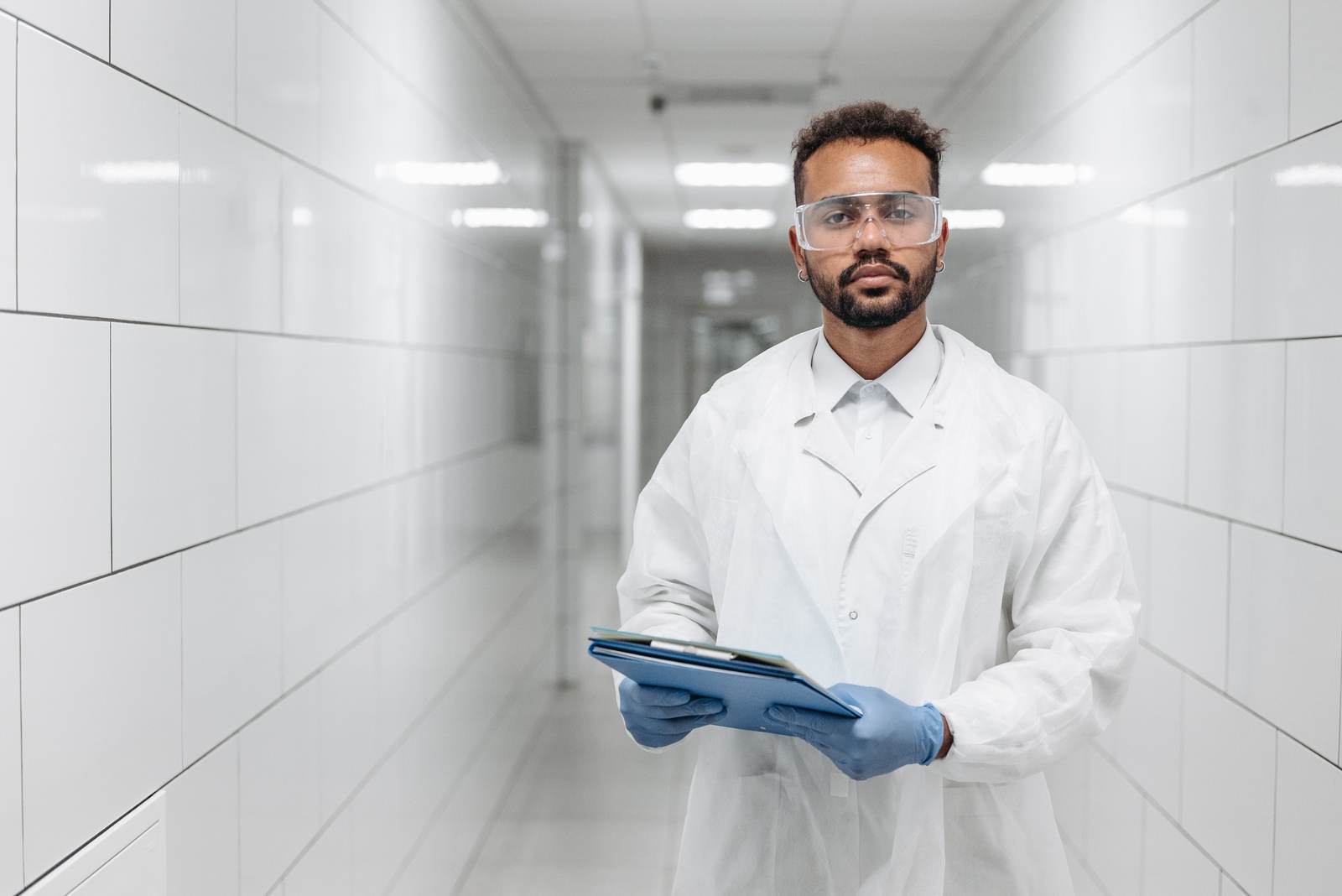 A scientist in protective gear in a laboratory hallway