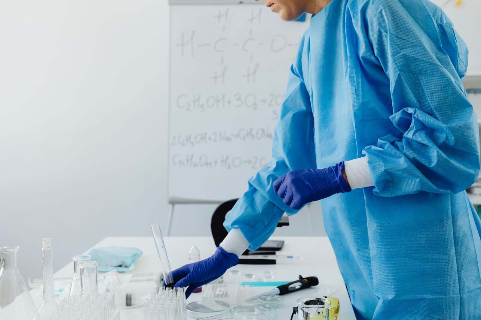 A scientist in protective clothing working with equipment in a biotechnology laboratory