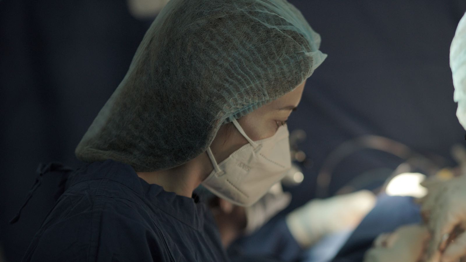 A focused surgeon wearing a mask during an operation