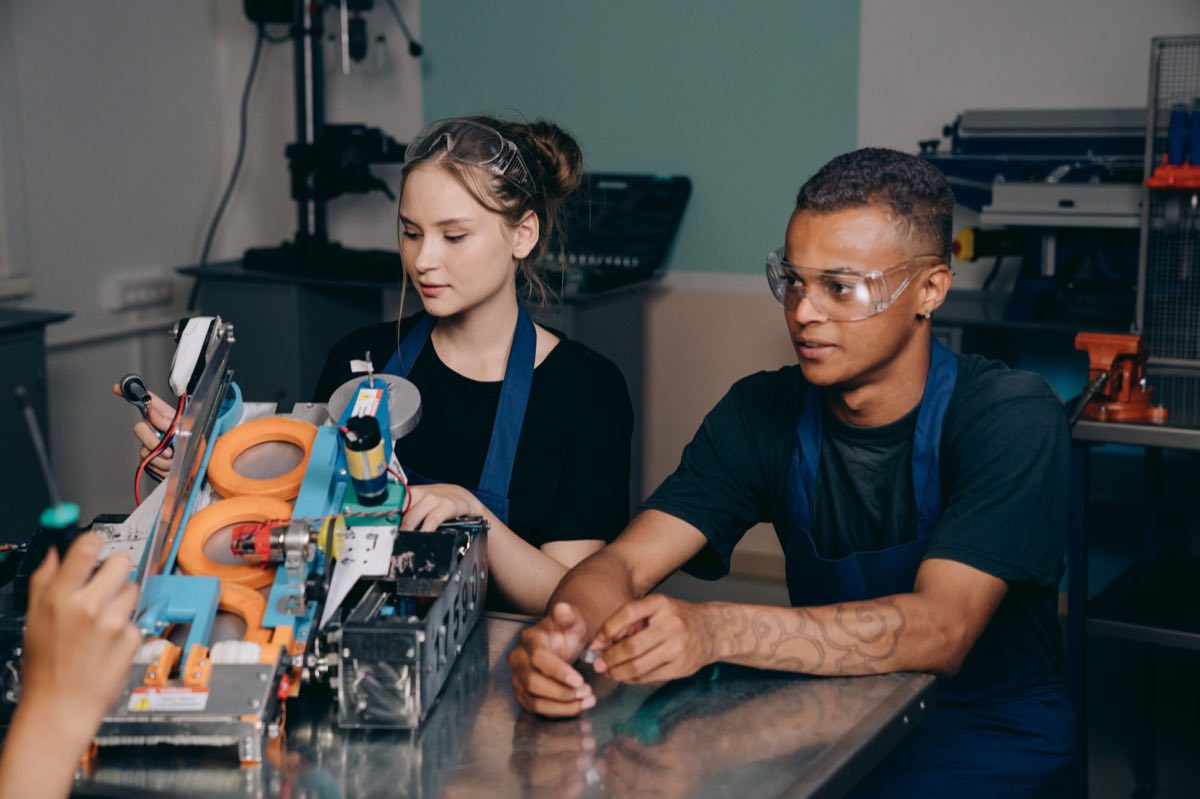 Two engineers working together on industrial equipment