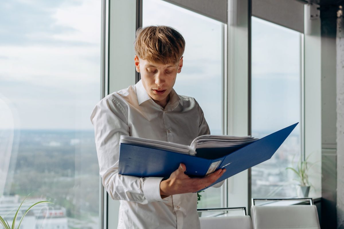 Executive reading a regulatory letter beside an office window