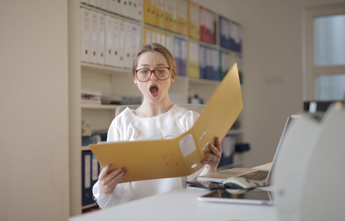 An auditor reviewing a technical file at a desk