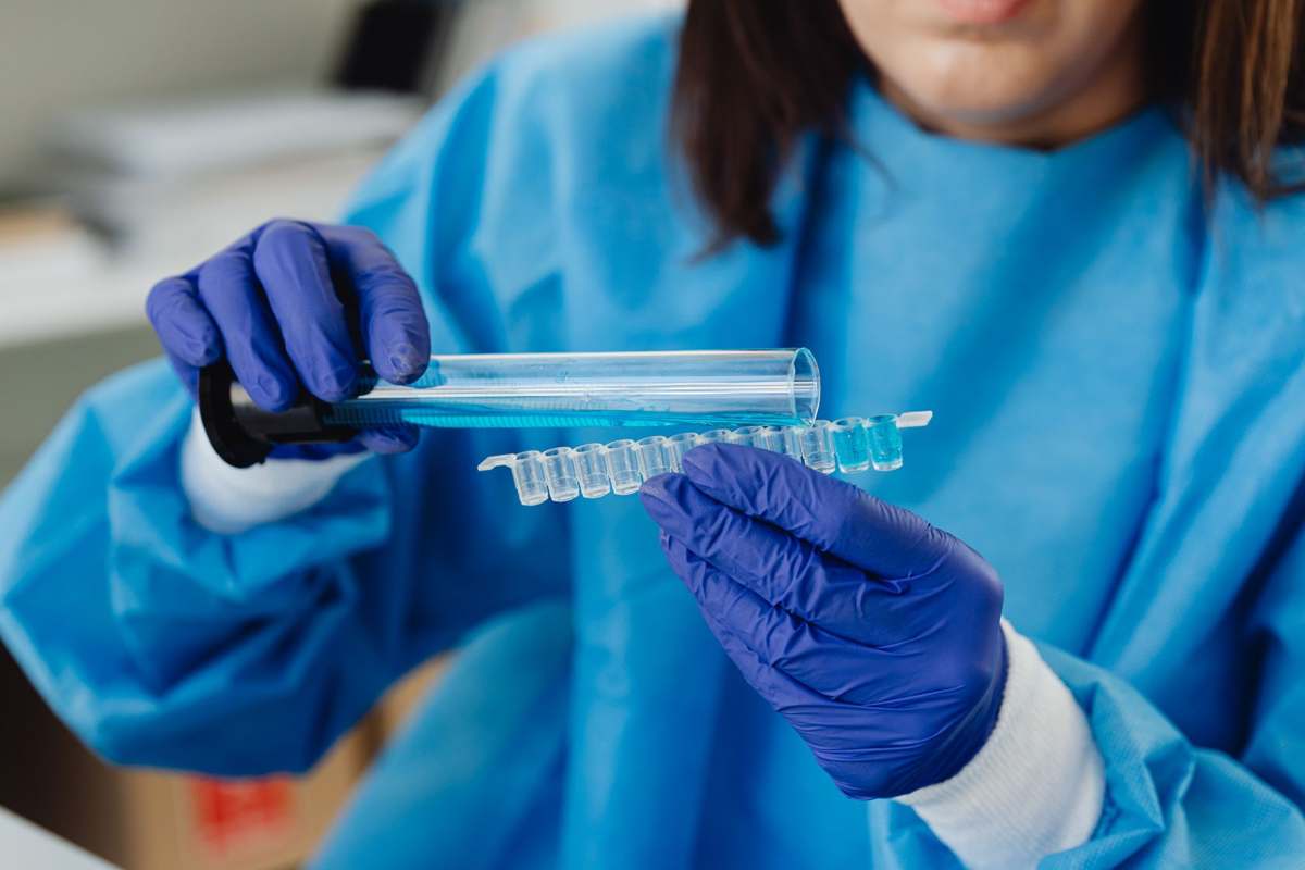 A scientist in protective gear handling laboratory samples