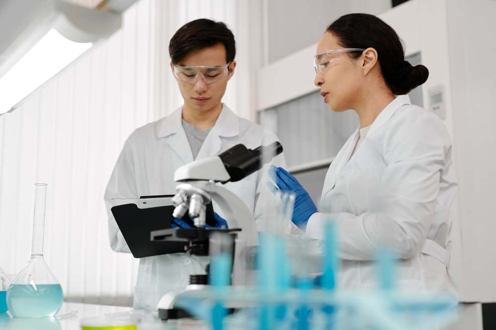 Scientists conferring in a cell processing laboratory