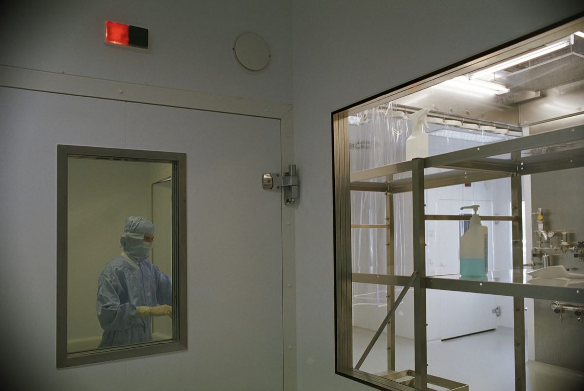 A cleanroom suite with sterile equipment and an operator in protective garb