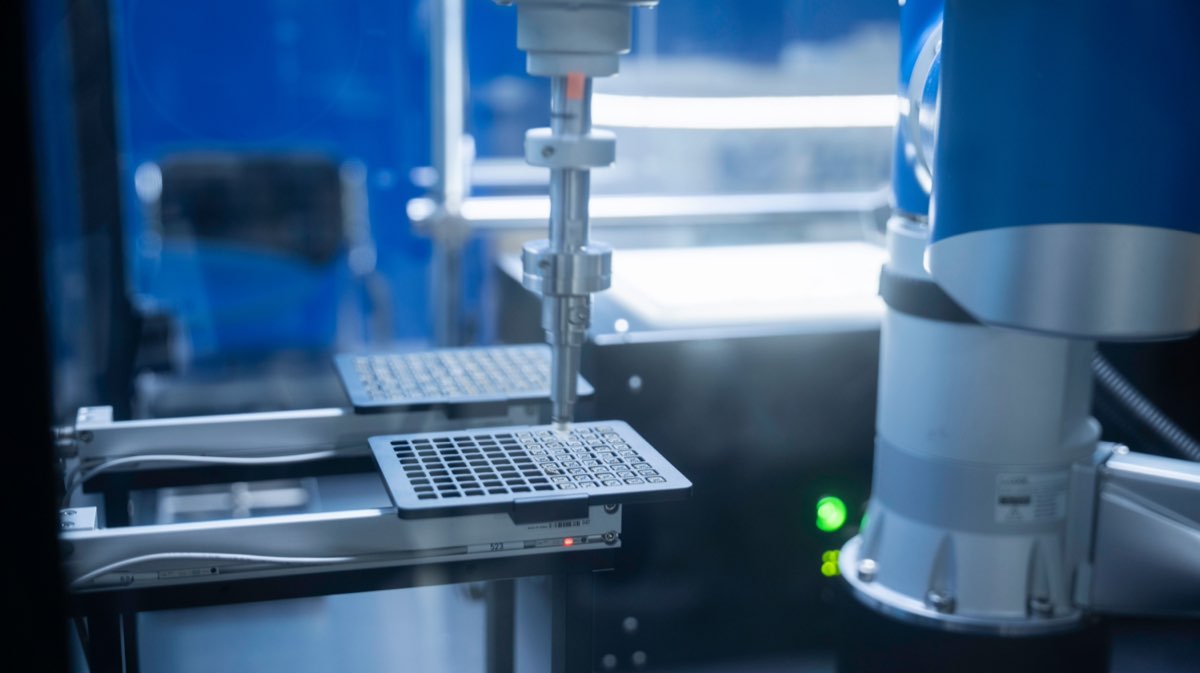 An automated liquid-handling robot running assay validation in a laboratory