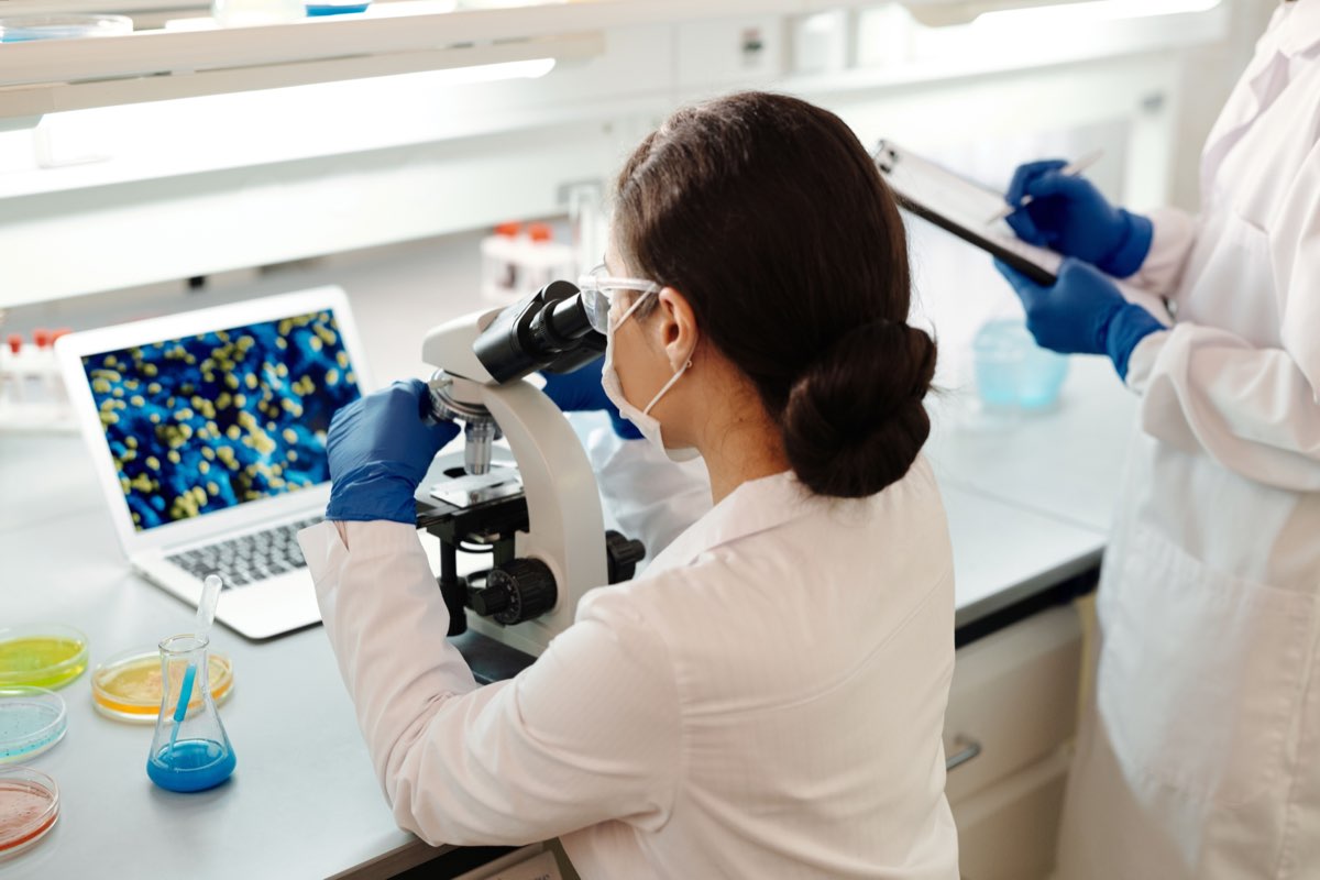 A scientist reviewing biomarker imaging at a microscope workstation