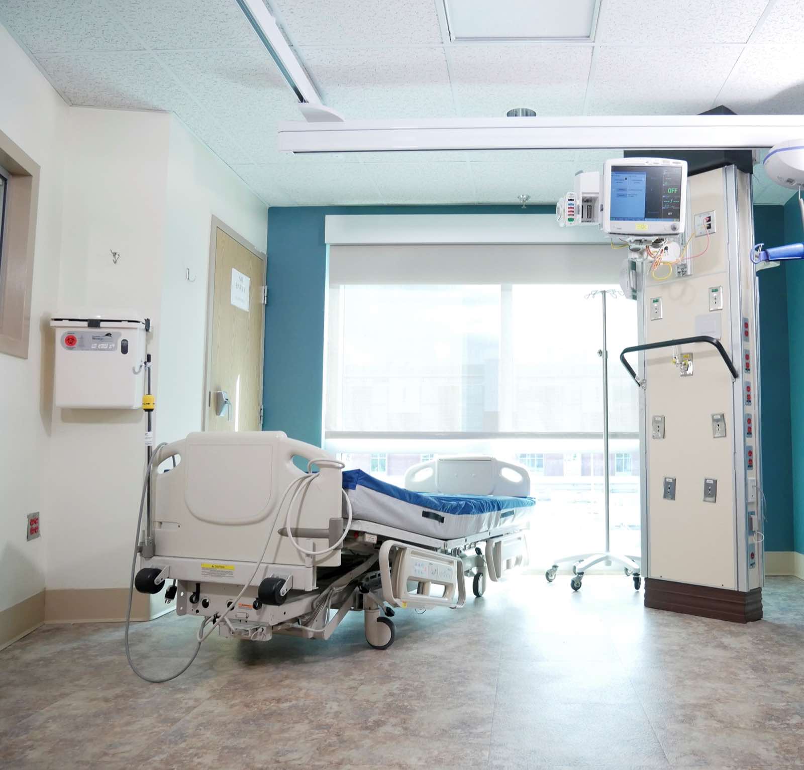 A well-equipped hospital room with a bed and advanced medical equipment