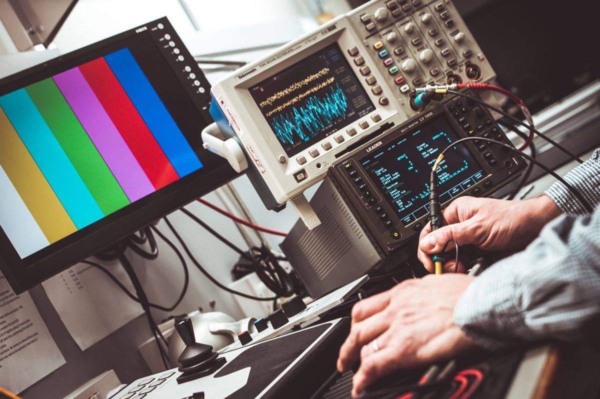 Technician operating laboratory measurement instruments with digital displays