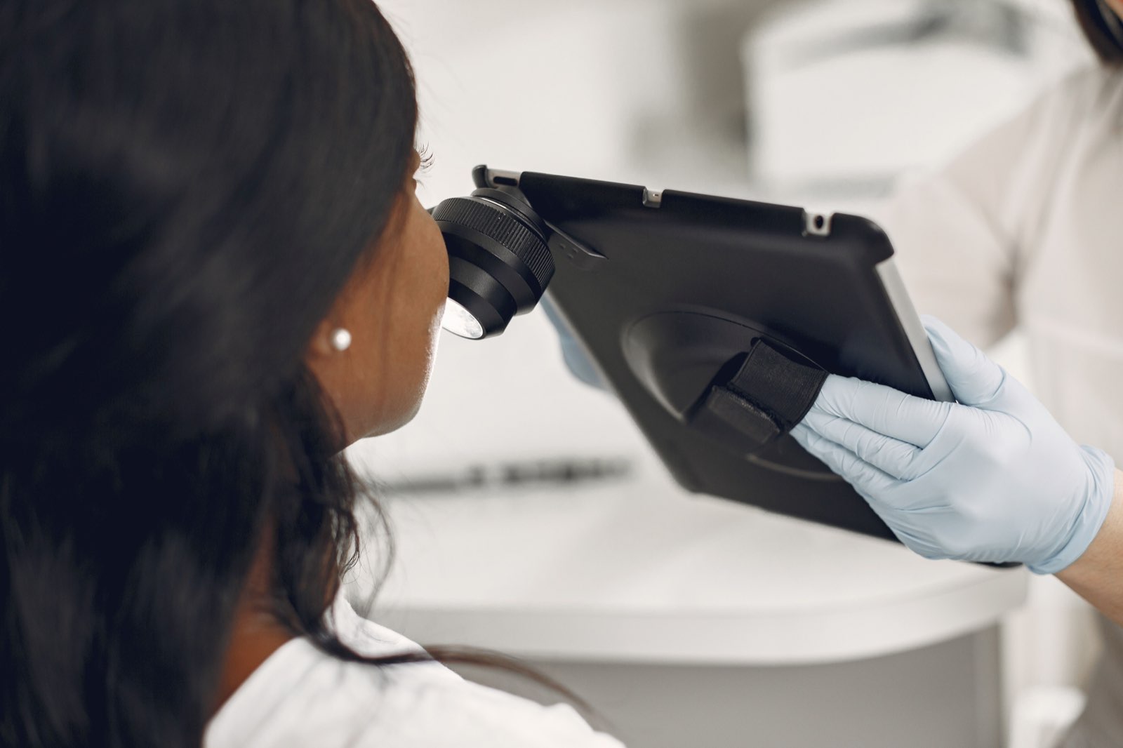 A dermatologist examining skin with a digital dermatoscope