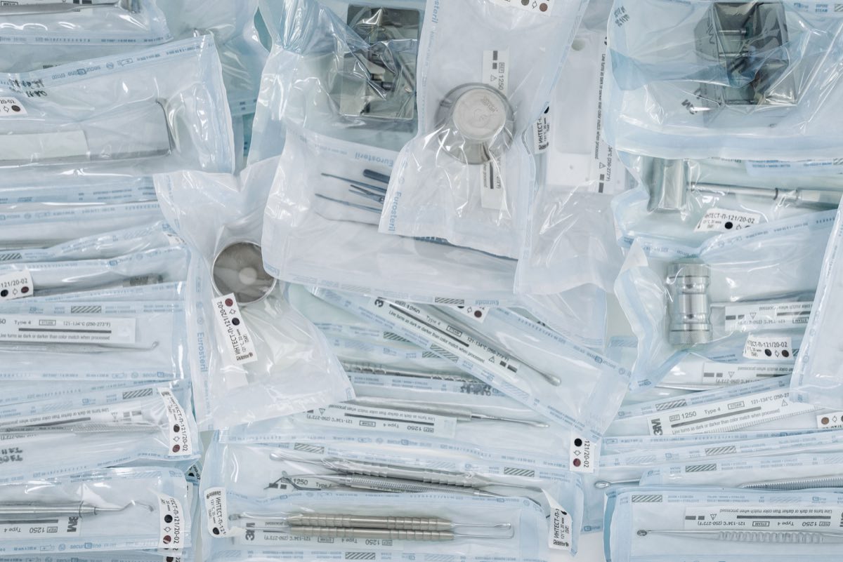 Rows of individually sealed sterile instruments on a tray