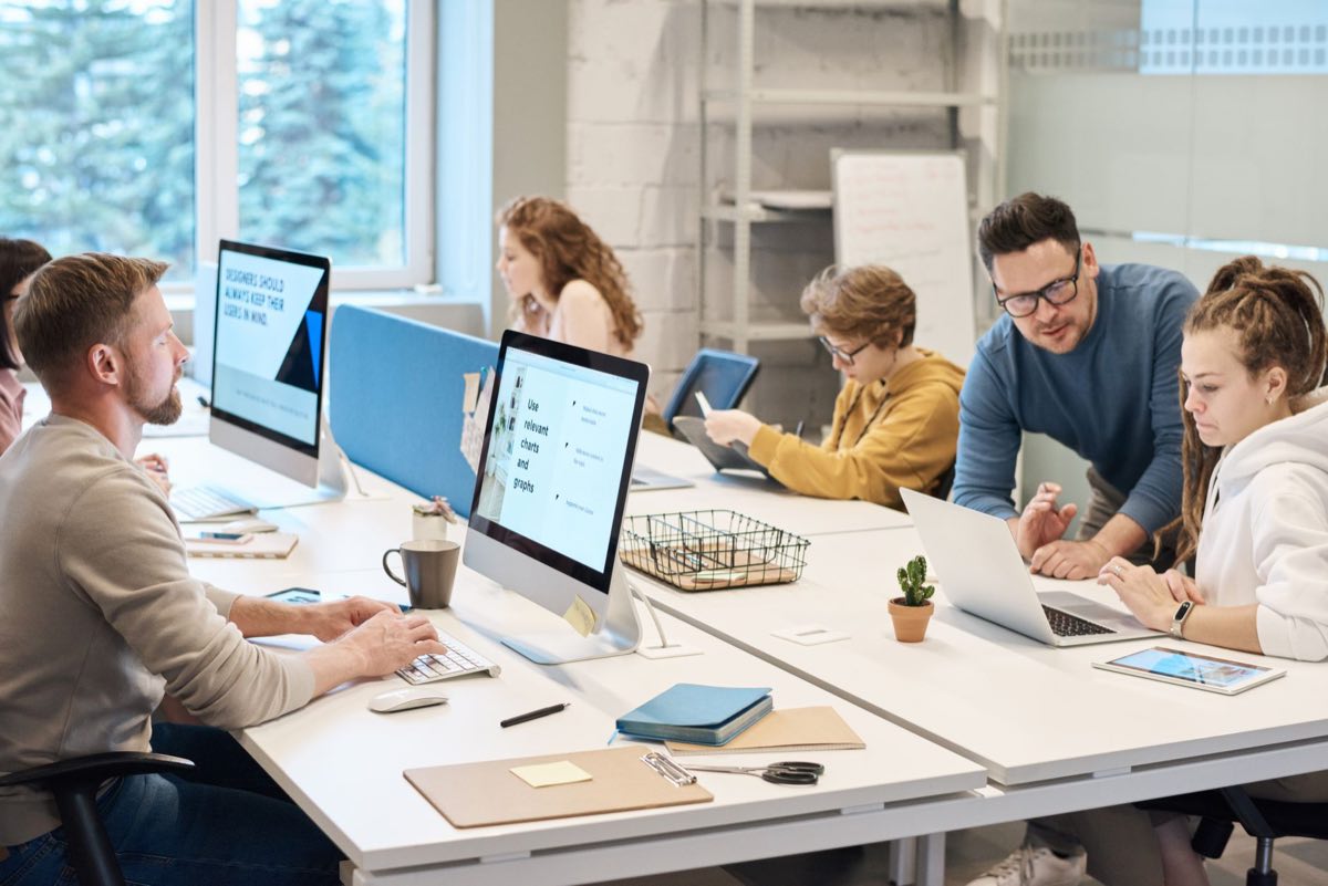 Team working together across computers in a modern office