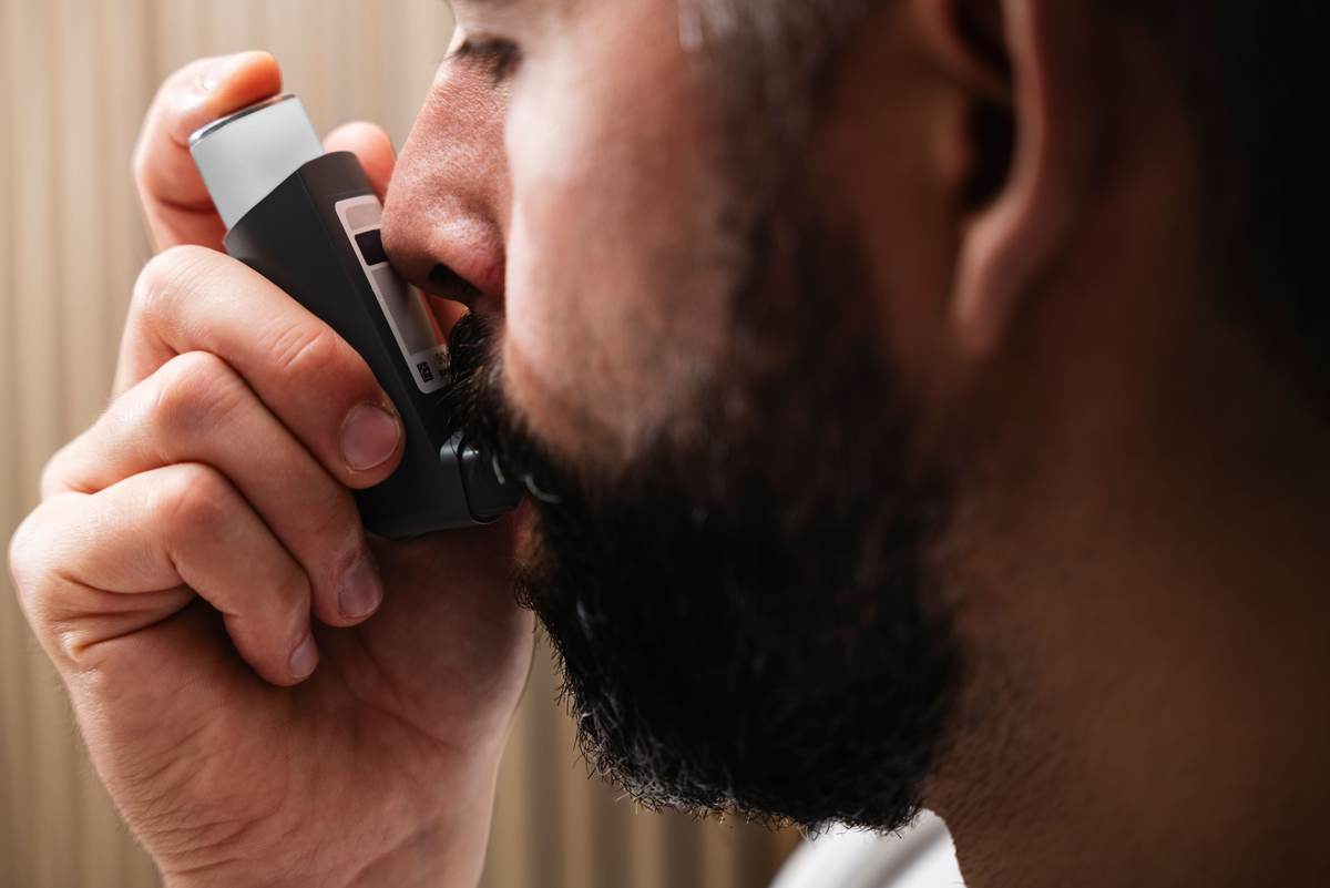 A close-up of a person using an inhaler device