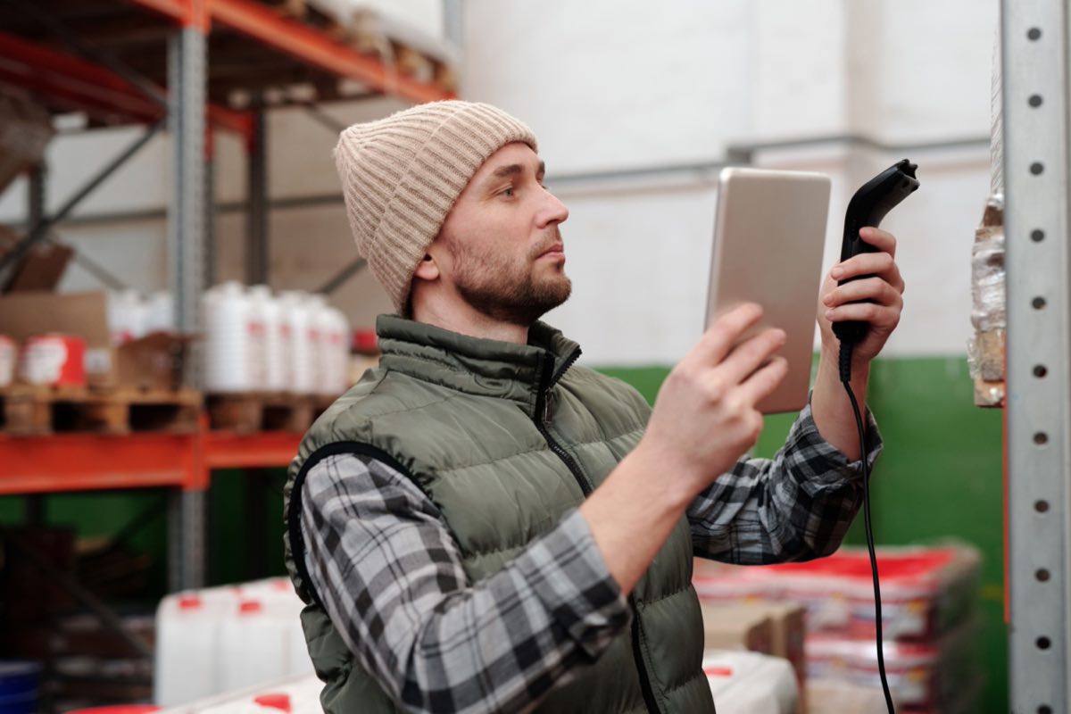 A warehouse professional checking inventory with a handheld scanner