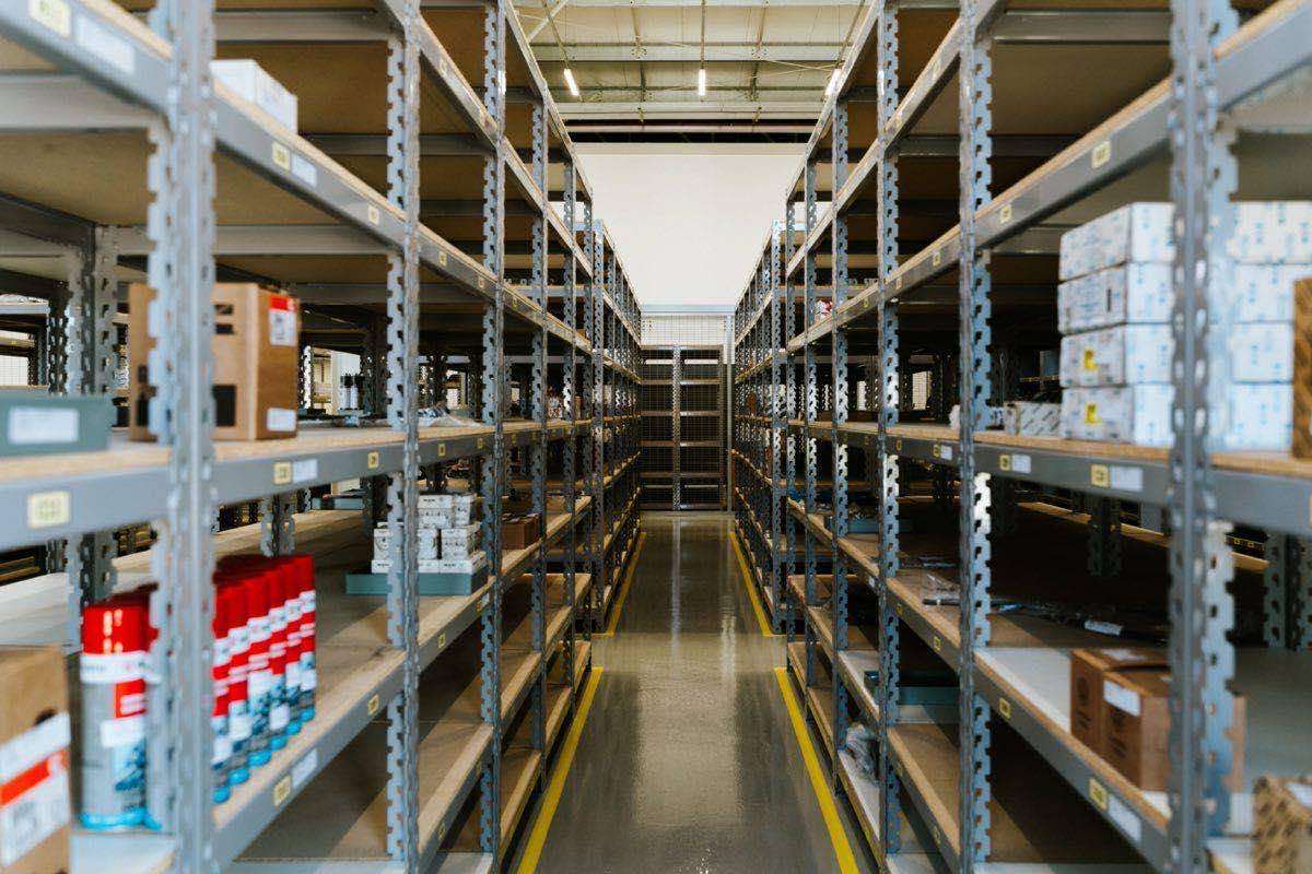 An organized industrial warehouse with tall stocked shelving