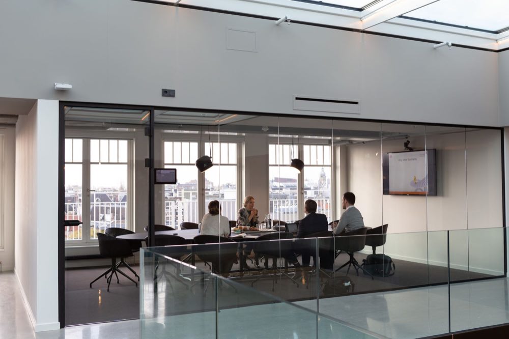 Senior European regulatory strategists meeting in a modern office overlooking the city