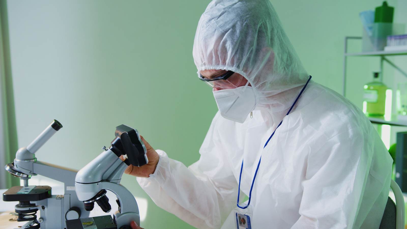 A scientist examining samples under a microscope