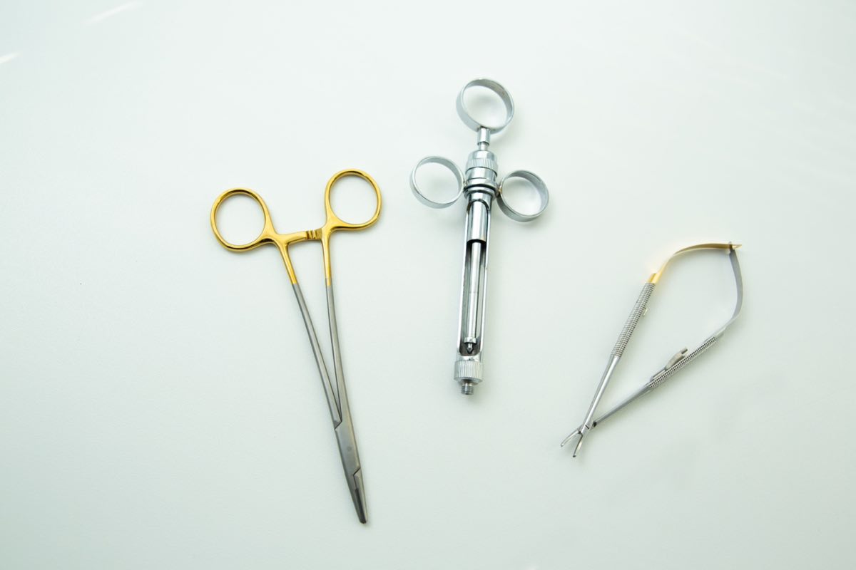 Close-up of surgical instruments on a clean white surface, highlighting precision tools