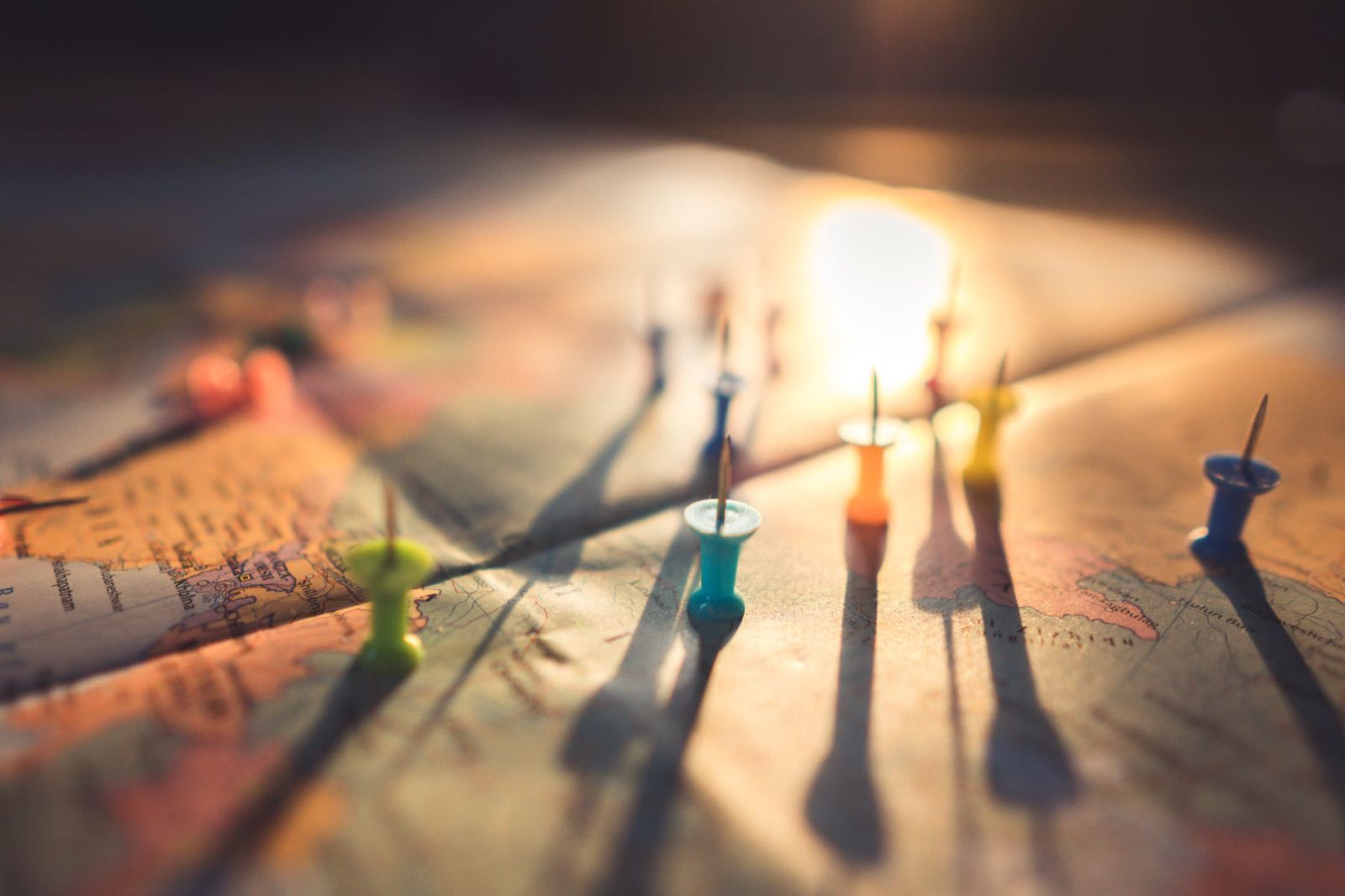 Push pins marking filing locations across a world map at dusk
