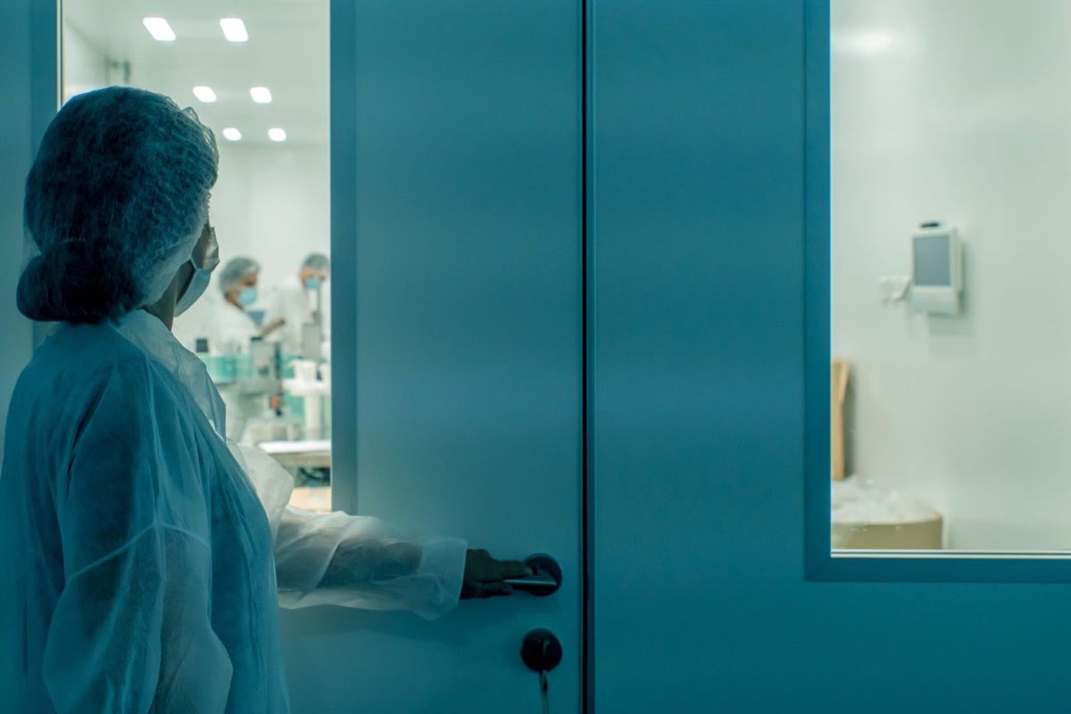 Technician gowning into a GMP manufacturing cleanroom