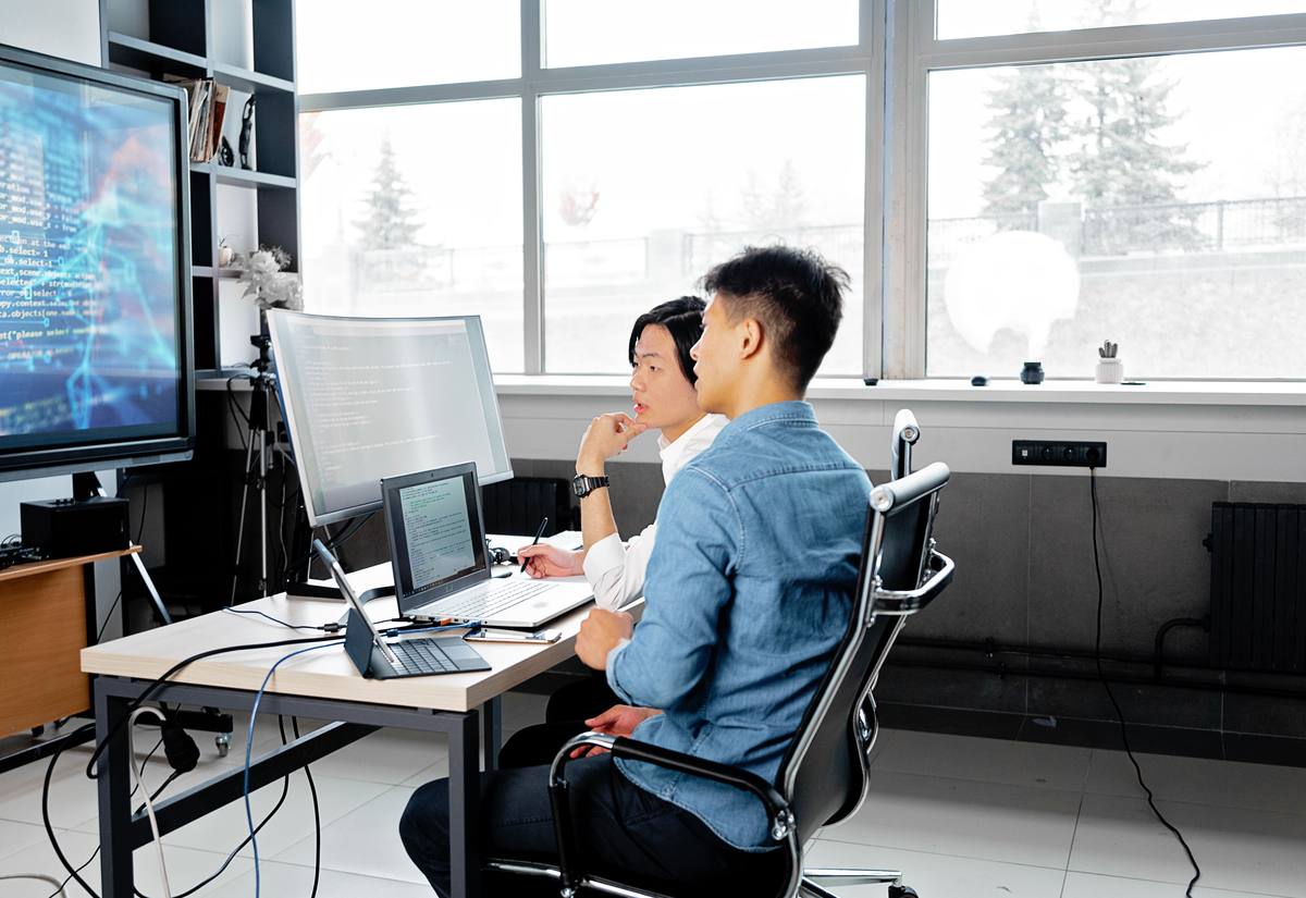 Engineers reviewing a machine-learning model dashboard on screen