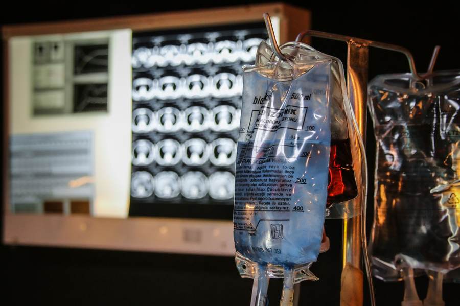 Labeled medical fluid bags in front of diagnostic imaging screens