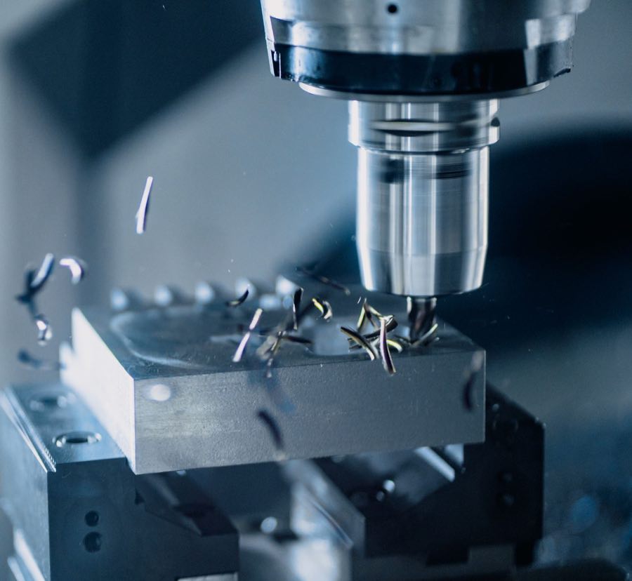 CNC milling machine cutting a precision metal component