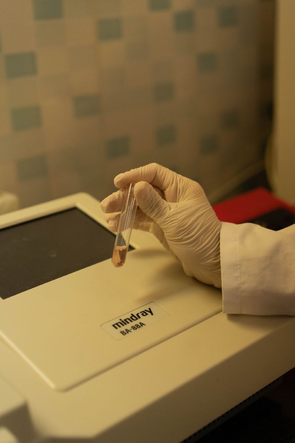 Technician loading a specimen vial into a diagnostic analyzer