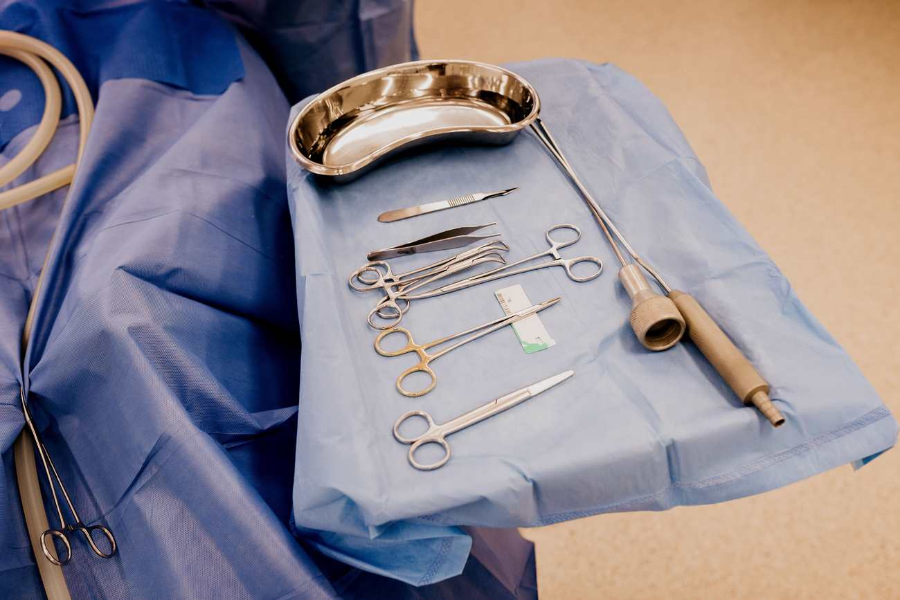 Sterile surgical instruments arranged on a blue drape