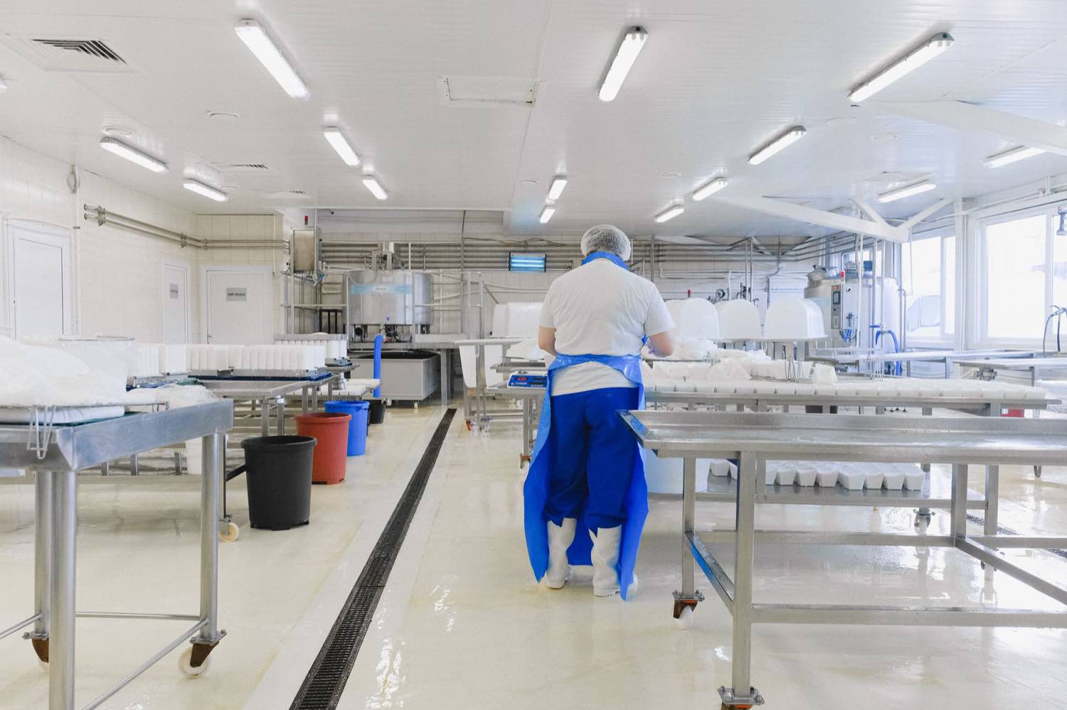 A gowned technician on a sterile pharmaceutical production floor