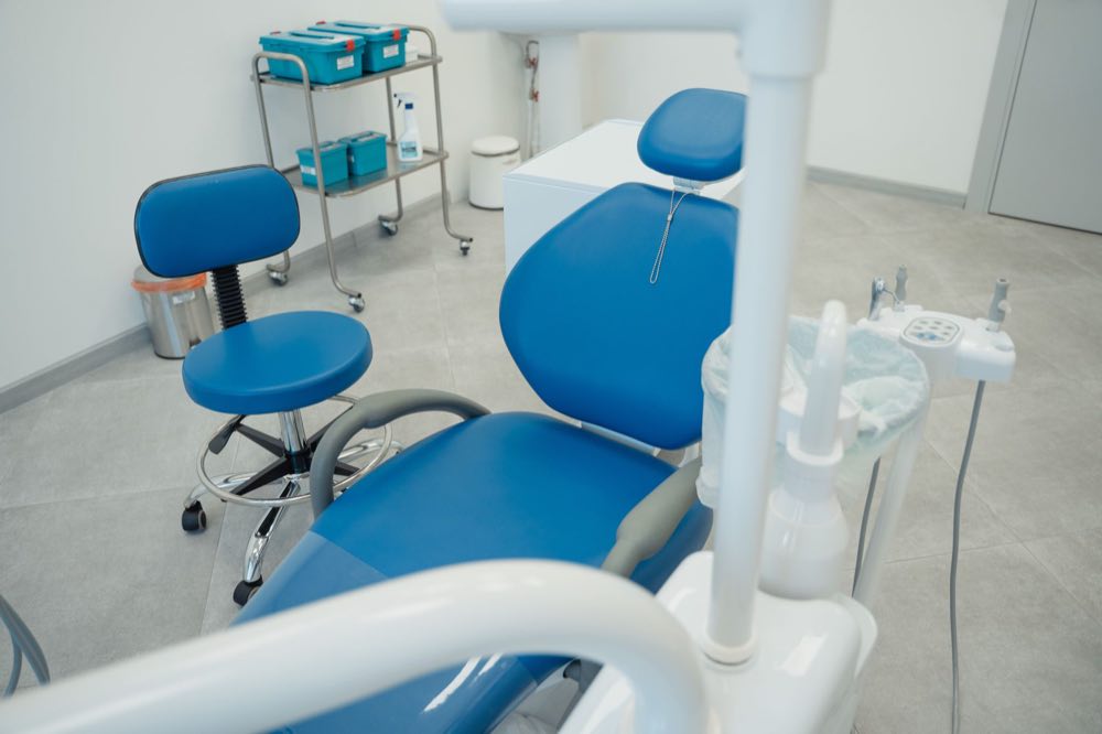 A clean and modern dental clinic featuring blue chairs and essential dental equipment