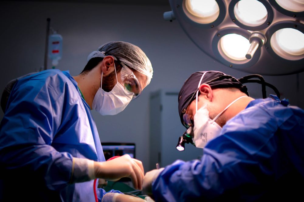 Focused surgeons performing a meticulous operation in a hospital operating room