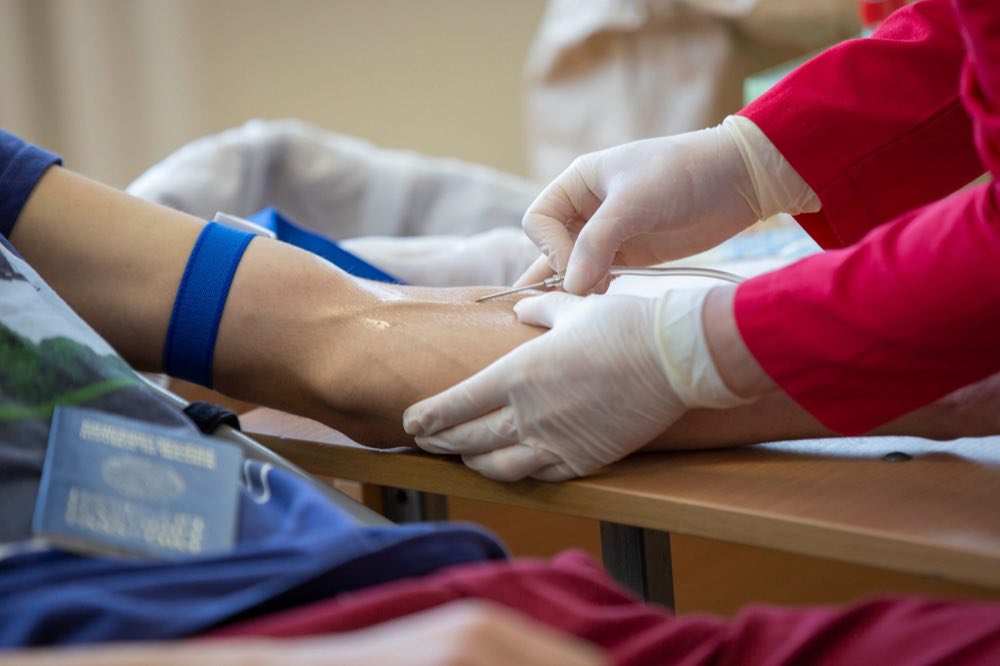 Close-up of a healthcare professional giving an injection to a patient in a hospital setting