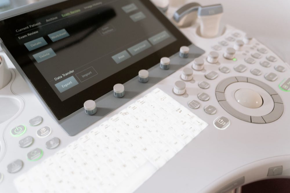Detailed view of a medical ultrasound machine control panel with buttons and screen