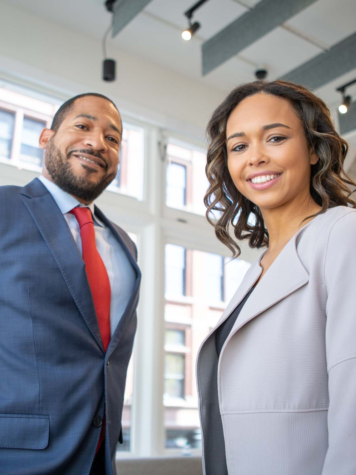Two smiling senior consulting partners standing in a bright modern New York office