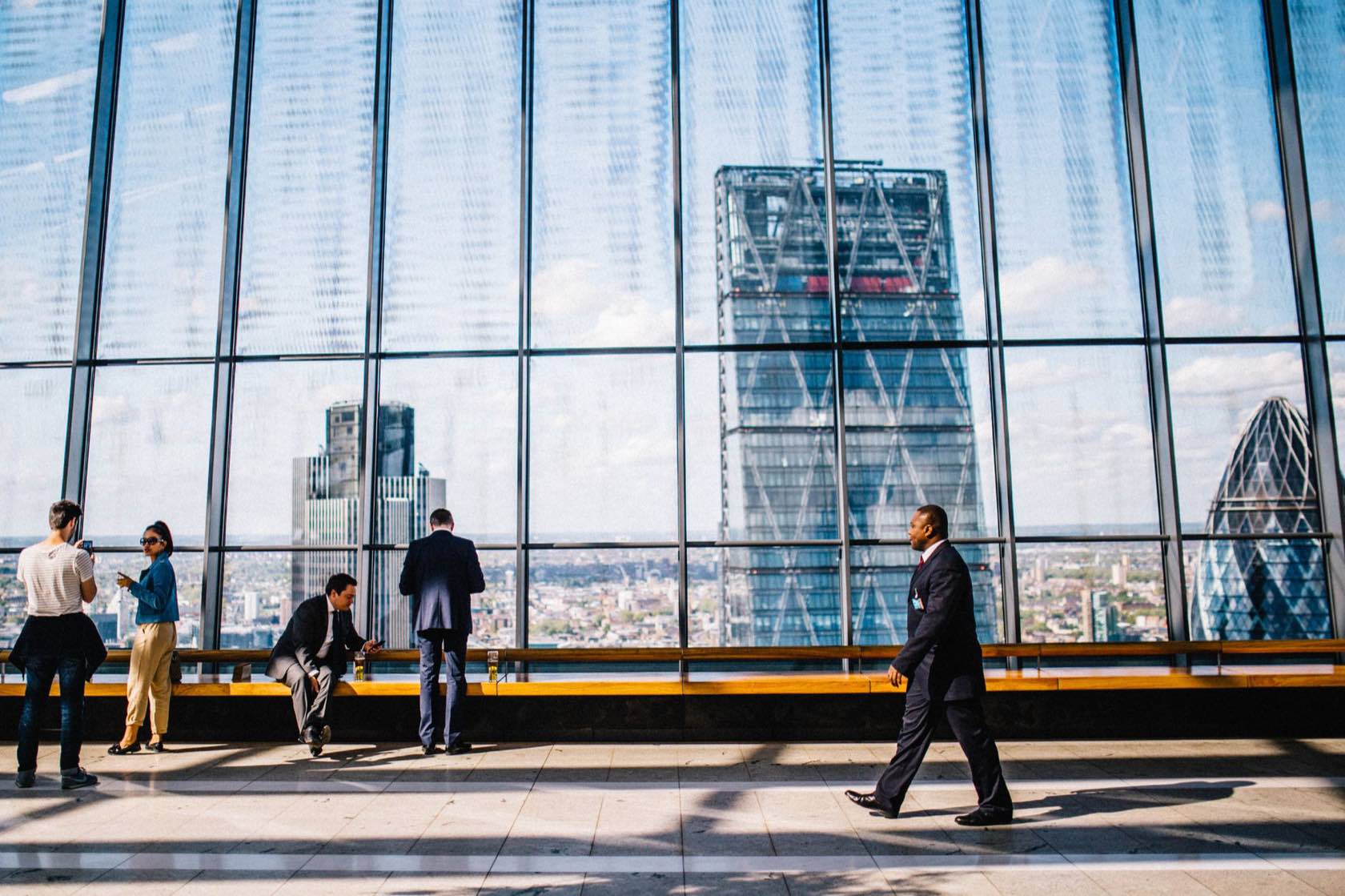 Executives at a floor-to-ceiling window high above the city skyline