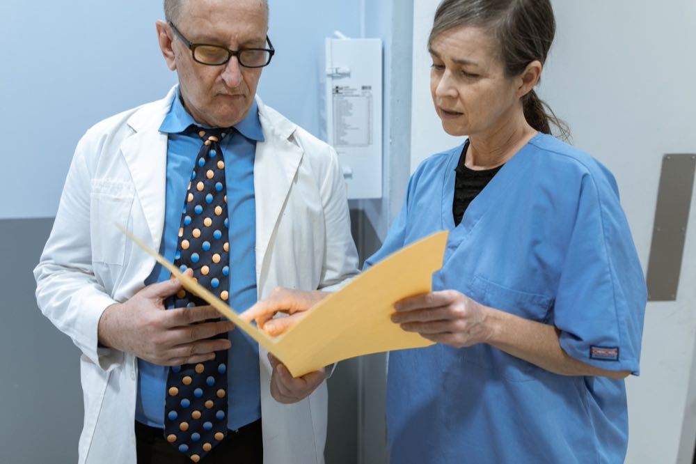 A doctor and nurse reviewing patient records together