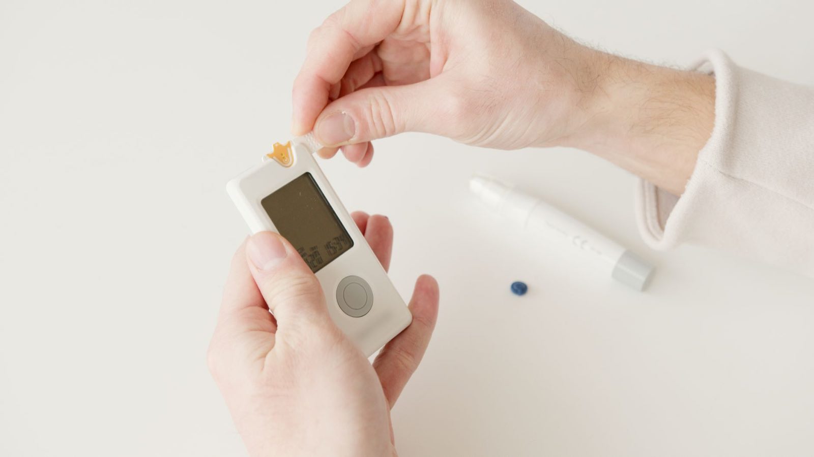 A person checking a blood glucose reading on a handheld medical device