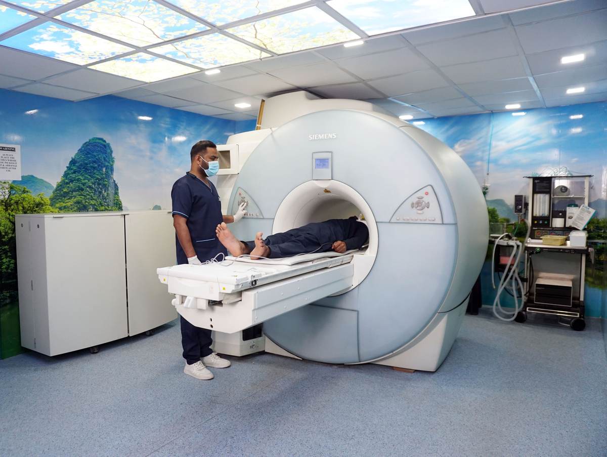 A medical technician assisting a patient with an imaging machine