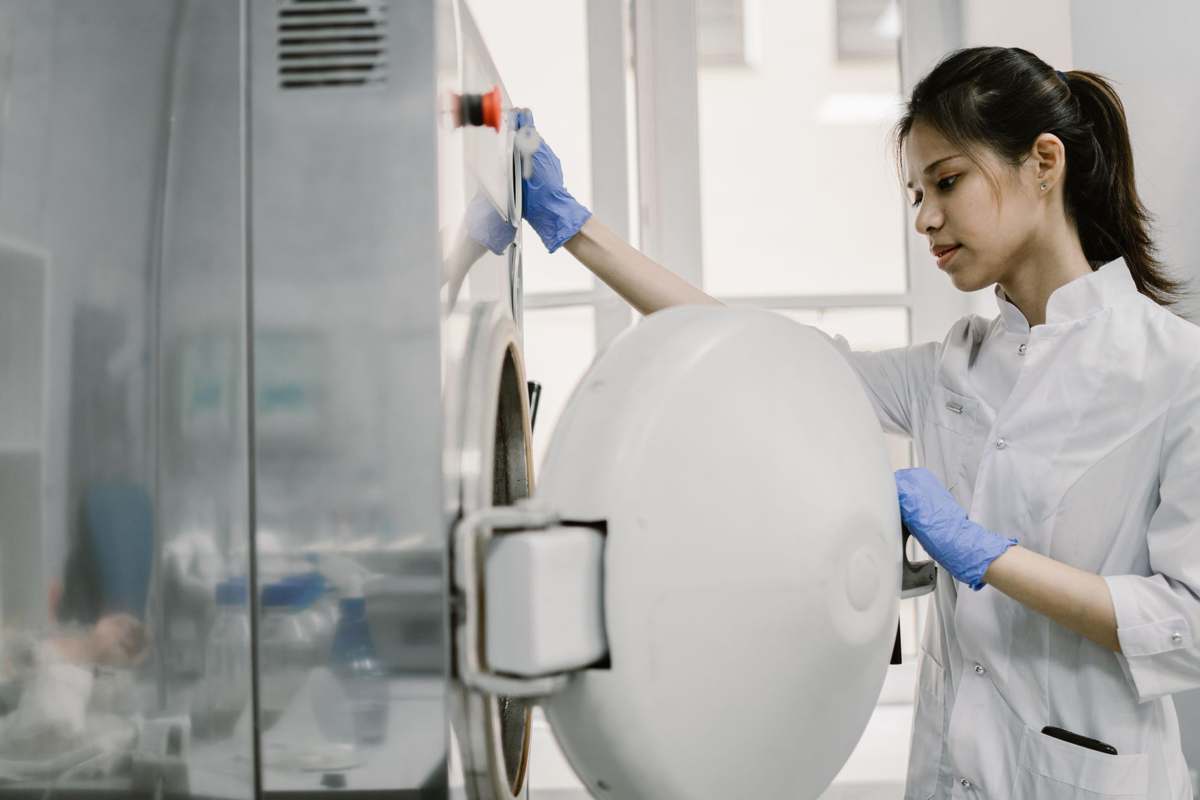 A laboratory technician operating clinical analyzer equipment