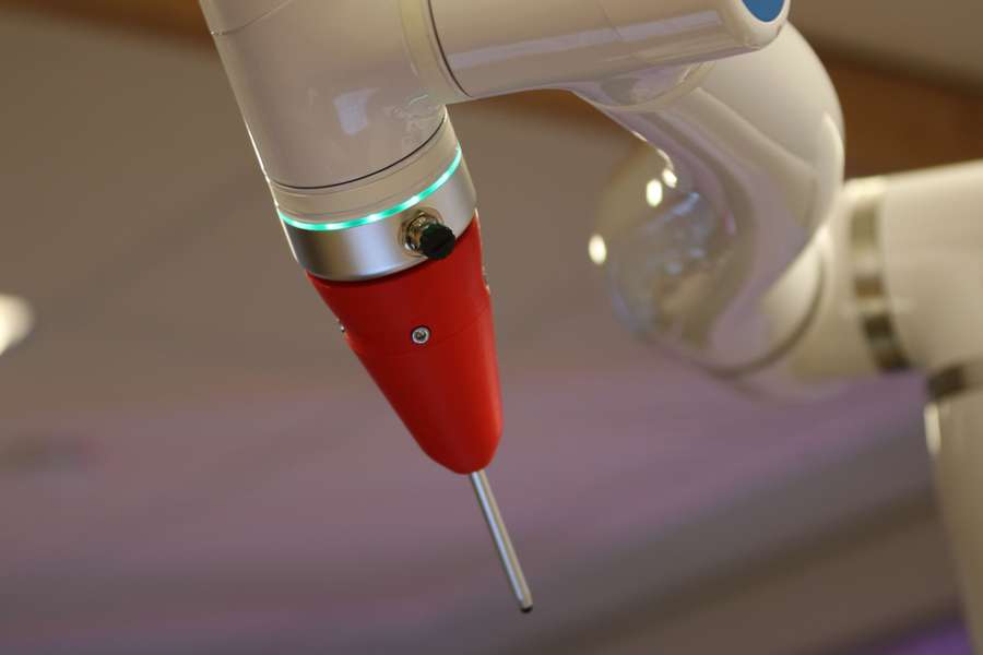 Precision robotic arm on a device manufacturing line