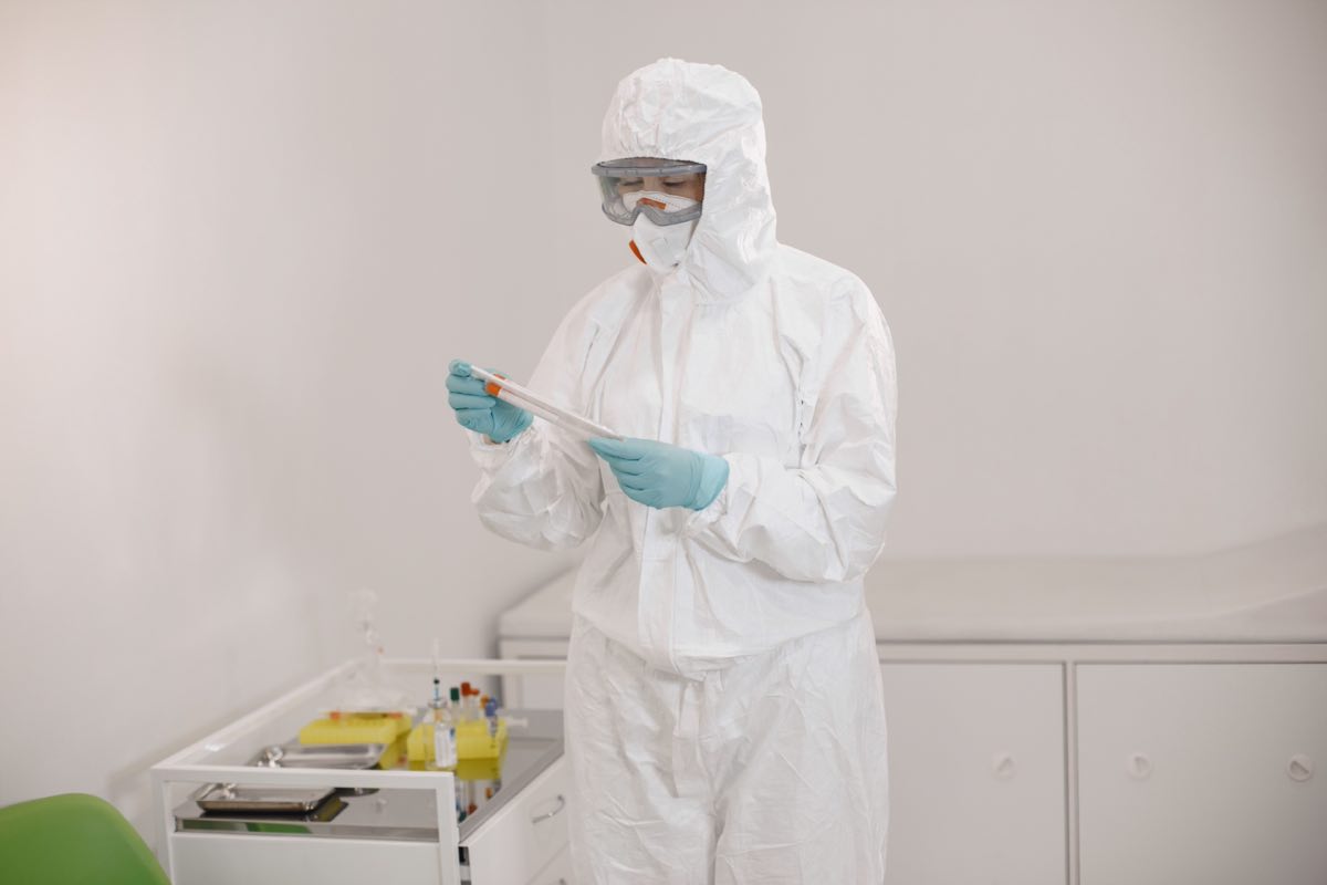 Scientist in protective equipment analyzing an infectious-disease sample