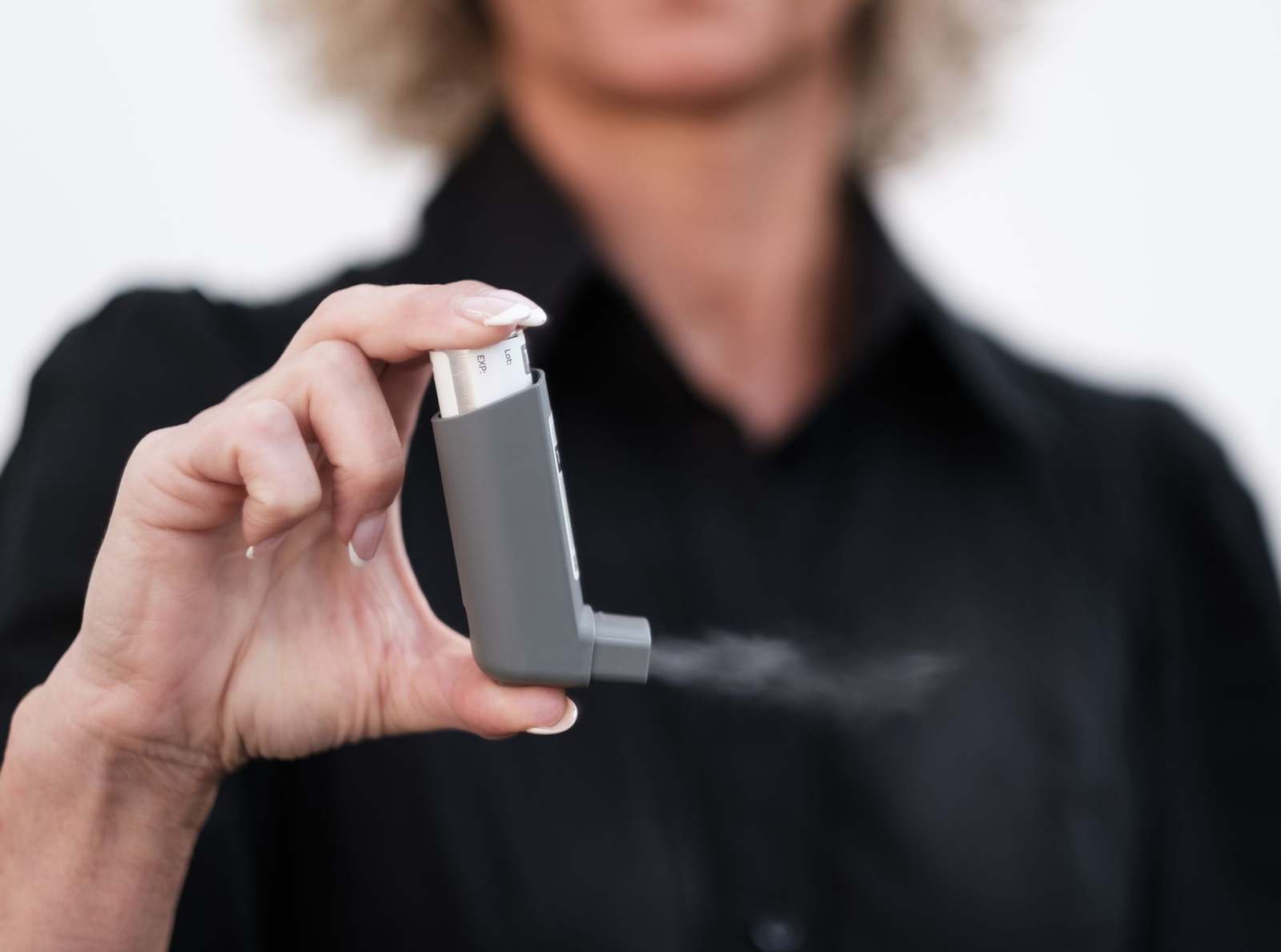 A person using a metered dose inhaler