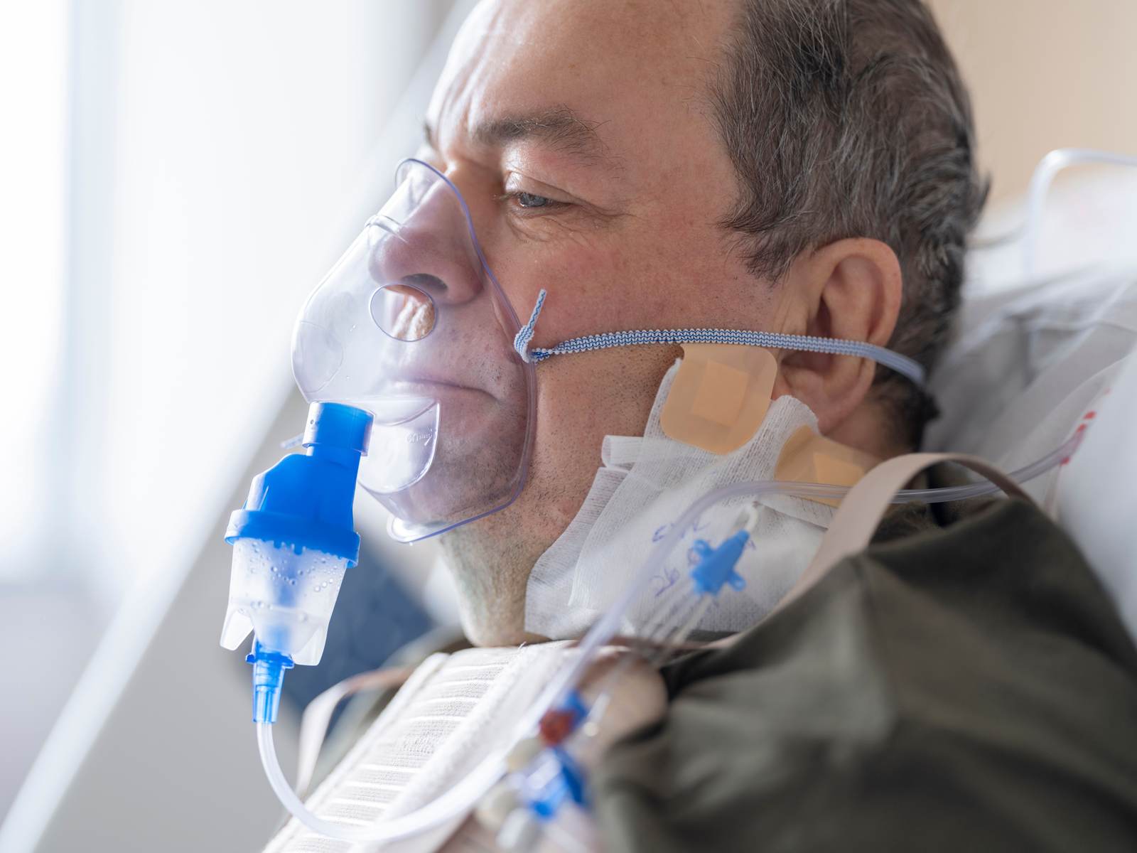 A senior patient using an oxygen mask in a hospital setting