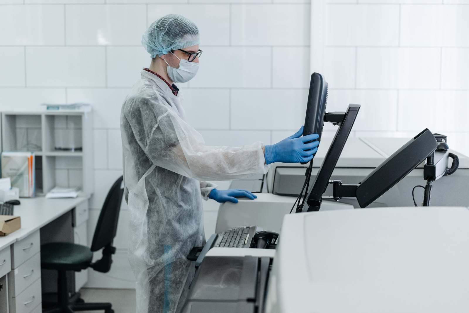A gowned operator working with laboratory production equipment