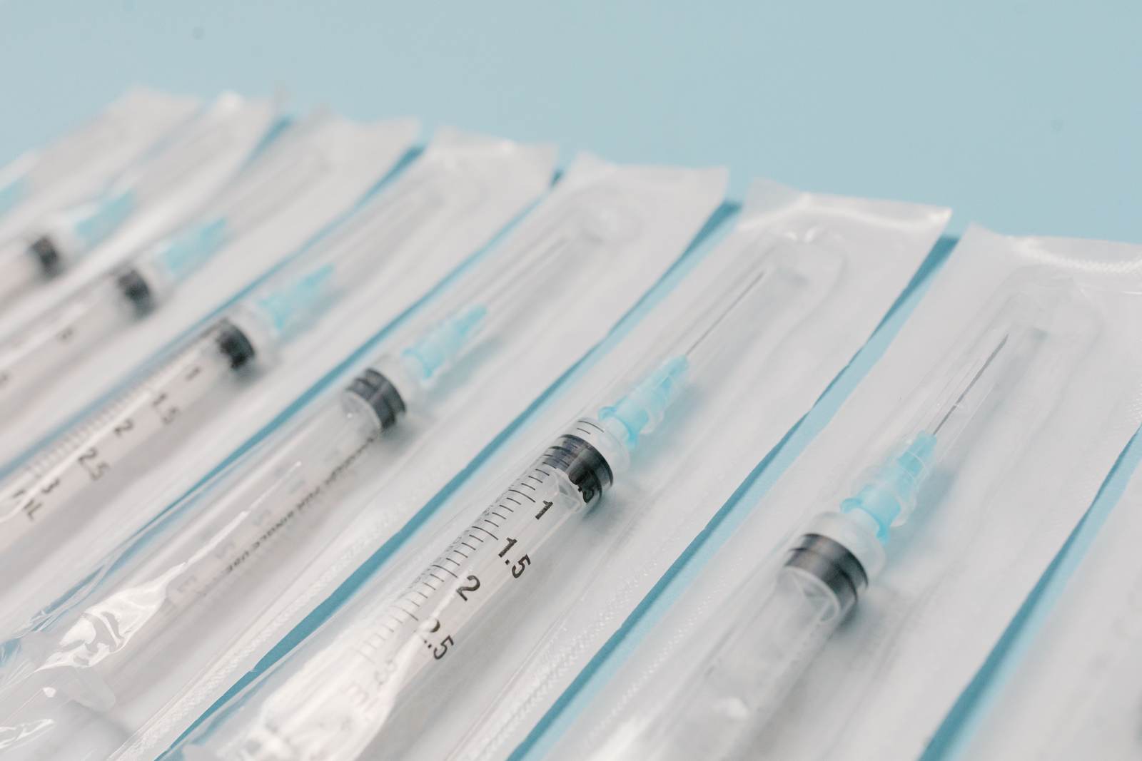 Sterile syringes aligned on a light surface